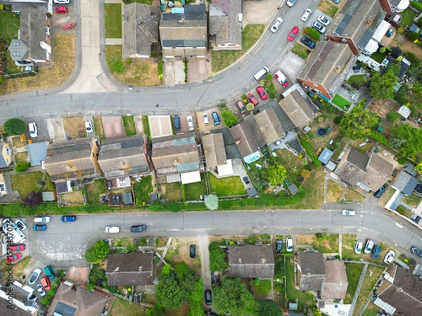 Fototapeta Drone view of a typical British suburban street showing both terraced and detached houses, some with large extensions and fitted solar panels to the roofs.