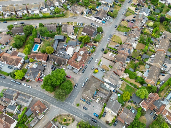 Fototapeta Drone view of a typical British suburban street showing both terraced and detached houses, some with large extensions and fitted solar panels to the roofs.