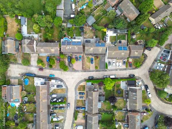 Fototapeta Drone view of a typical British suburban street showing both terraced and detached houses, some with large extensions and fitted solar panels to the roofs.