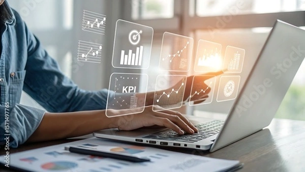 Fototapeta Photo of a person uses a laptop to analyze business data displayed as interactive charts and graphs