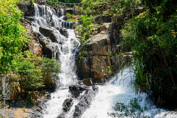Fototapeta Rushing Datanla Waterfall Cascading Over Rocky Cliffs in the Lush Green Forest of Da Lat, Vietnam