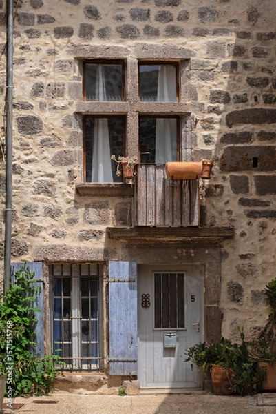 Obraz Vieille maison en pierre d'un village typique du Sud de la France avec ses tours de fenêtre en pierre du Moyen-âge et ses volets bleus lavande.