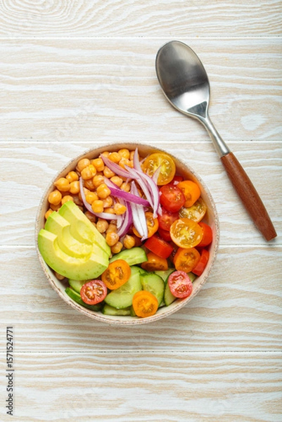 Obraz Healthy chickpea salad with ripe avocado, juicy cherry tomatoes, crisp cucumber, and red onion slices. Perfect for a nutritious and healthy meal