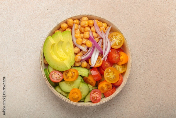 Obraz Healthy chickpea salad with ripe avocado, juicy cherry tomatoes, crisp cucumber, and red onion slices. Perfect for a nutritious and healthy meal, light beige background
