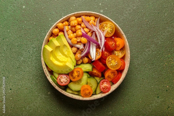 Obraz Healthy chickpea salad with ripe avocado, juicy cherry tomatoes, crisp cucumber, and red onion slices. Perfect for a nutritious and healthy meal on green background