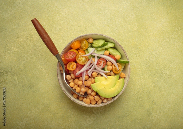 Obraz Healthy chickpea salad with ripe avocado, juicy cherry tomatoes, crisp cucumber, and red onion slices. Perfect for a nutritious and healthy meal on light green background
