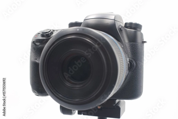 Fototapeta Professional DSLR camera with large lens positioned on a tripod against a white background