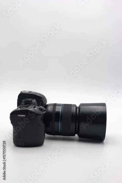 Fototapeta Digital camera with a large lens positioned horizontally on a plain background showcasing its design and features