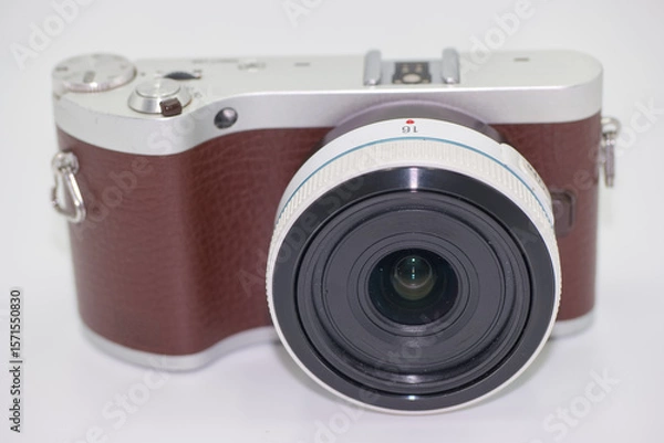 Fototapeta Compact camera with a stylish design featuring a brown leather grip and wide angle lens on a clean background