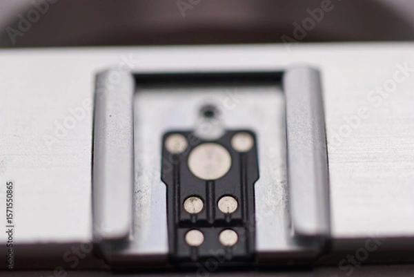 Fototapeta Close up view of a metal component with electrical contacts on a smooth surface in a workshop setting