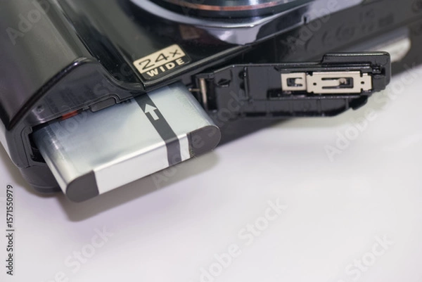Fototapeta Close up view of a digital camera battery compartment showing battery insertion process