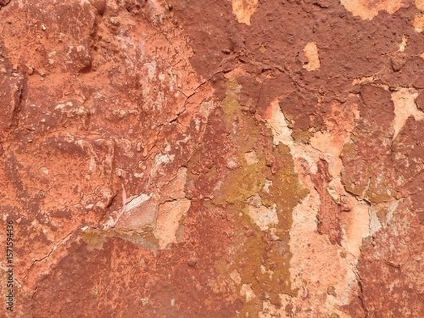 Fototapeta Warm-toned brick texture with peeling orange and red layers for rustic design themes and decay visuals