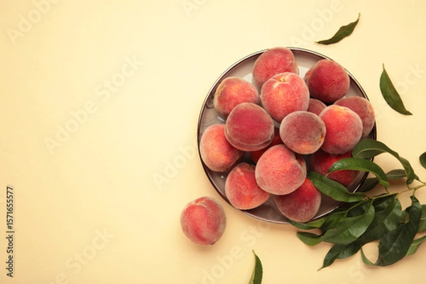 Obraz Sweet peaches and leaves on dark plate on beige background. Space for text