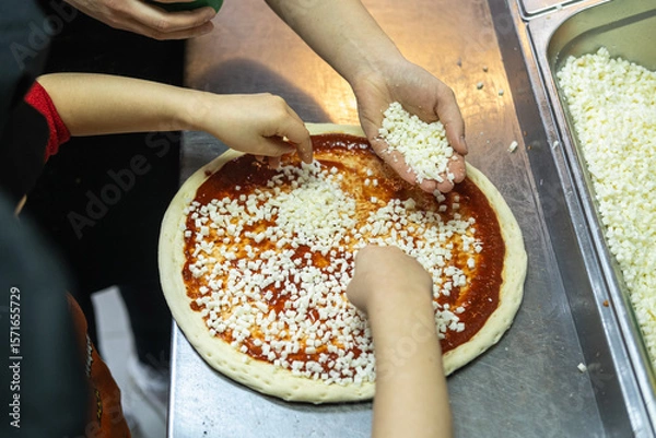 Fototapeta Children participate in a pizza-making master class. 