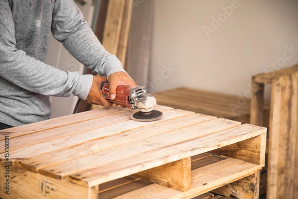 Fototapeta Wood sanding machines , Carpenter working with electrical sander on pine floor or table surface