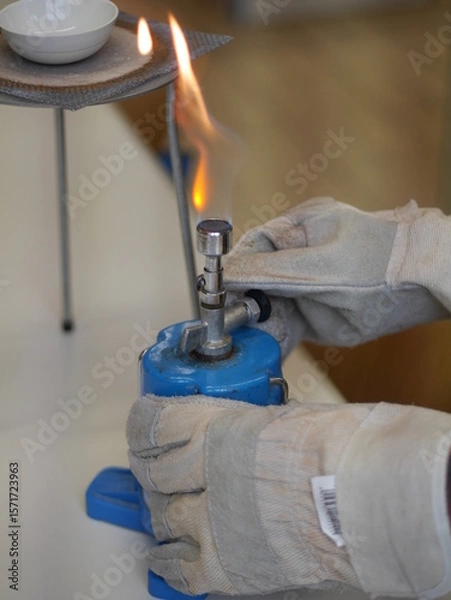 Obraz Person is holding a blue object with a flame on it