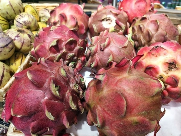 Fototapeta A bunch of red fruits with a few green leaves
