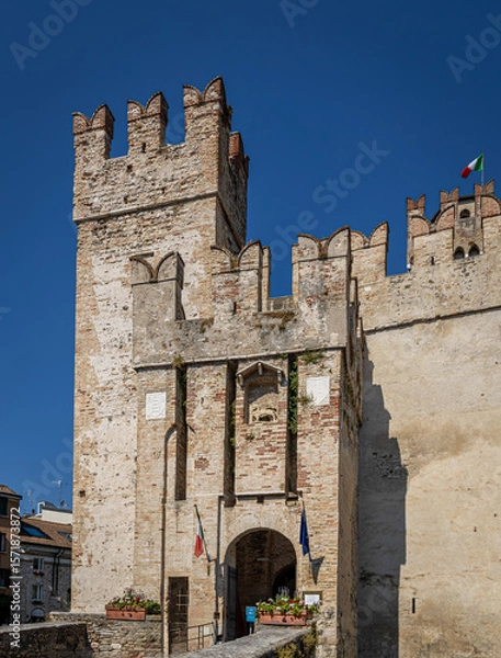 Fototapeta Aerial view of historic Scaliger Castle in Sirmione, Italy, surrounded by mountains
