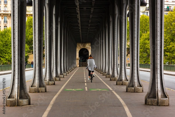 Obraz Metal columns and abutments of '' Bir Hakeim '' bridge. People walks and make jogging under the bridge in Paris.The bridge is one of the most famous and historic landmark