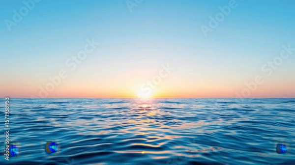Fototapeta The ocean is calm and the sun is setting, creating a serene