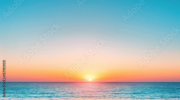 Fototapeta The ocean is calm and the sky is a beautiful shade of pink