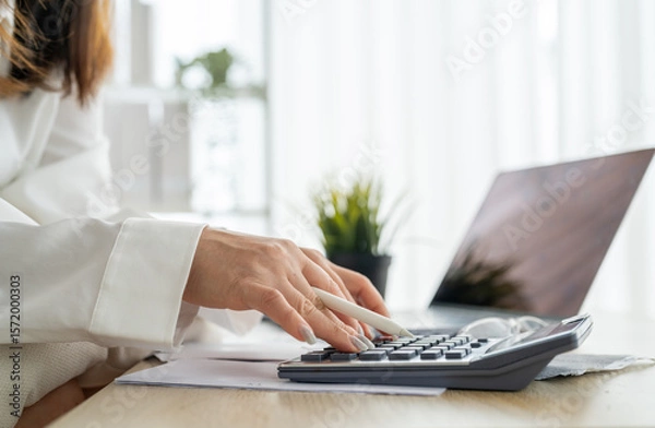 Fototapeta Human use calculator and calculate bills and paying bill, credit card, tax and vat, payment, concept of money management and business report with financial documents, financial accounting concept