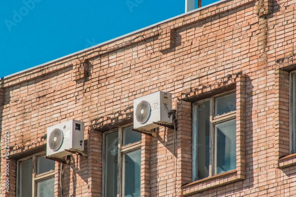 Fototapeta Air conditioners on the wall of an old brick building