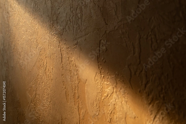Fototapeta Rustic Plaster Wall with Sunlight and Shadow Casting Dramatic Textures