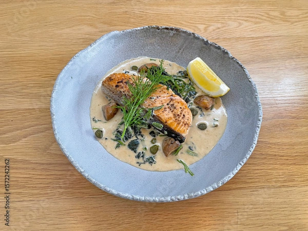 Fototapeta Salmon steak in creamy white wine sauce 