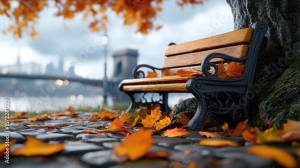 Fototapeta Empty bench placed under a tree, leaves scattered around.