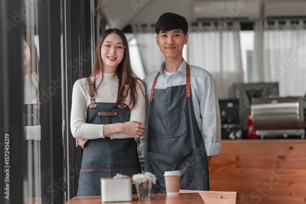 Obraz Bright atmosphere of success coffee shop owners smiling together in a friendly urban space