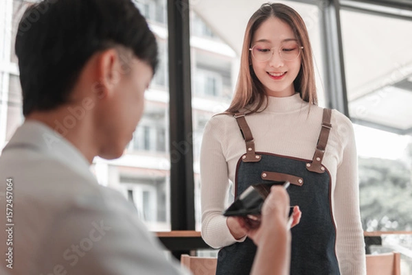 Obraz Payment exchange between young adults at a trendy , social interaction scene, modern vibe