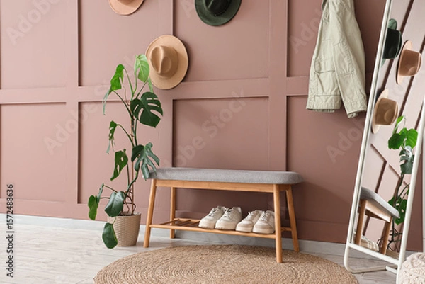 Fototapeta Interior of stylish hallway with soft bench, palm plant and mirror