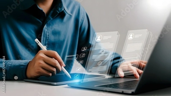 Fototapeta A businessman uses a stylus and laptop to review candidate resumes on a digital interface, emphasizing the recruitment process