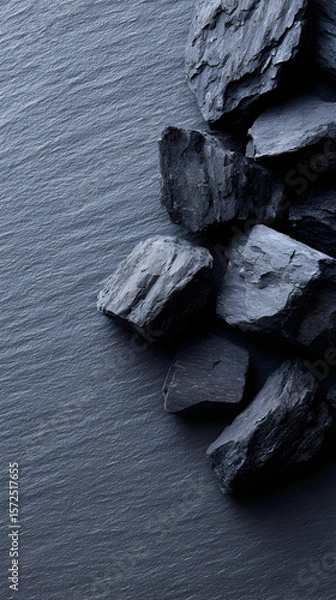 Obraz Dark textured stones arranged on a slate surface, showcasing natural patterns and colors, creating a visually striking and calming atmosphere for design and decoration purposes