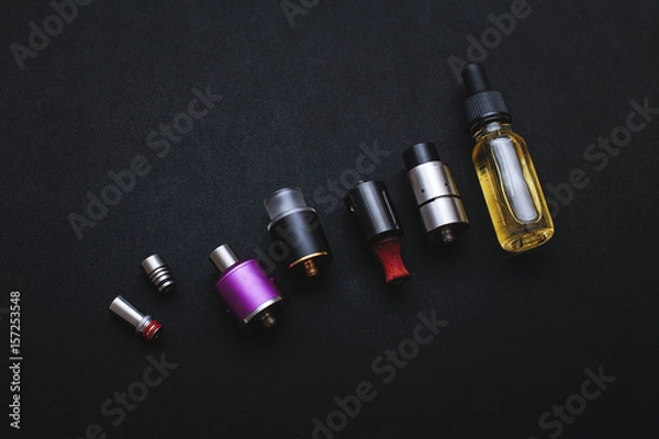 Fototapeta Popular vaping device mod.Upgrade parts for modern vaporizer e-cig device,spare parts.New device model,micro coil clearomizer.Quit smoking nicotine cigarette,start vaping safe ecig vape