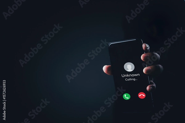 Fototapeta Hand holding mobile phone with unknown caller notification, concept of telephone fraud, call blocking, digital security, unwanted calls, anonymous communication, phishing attempt.