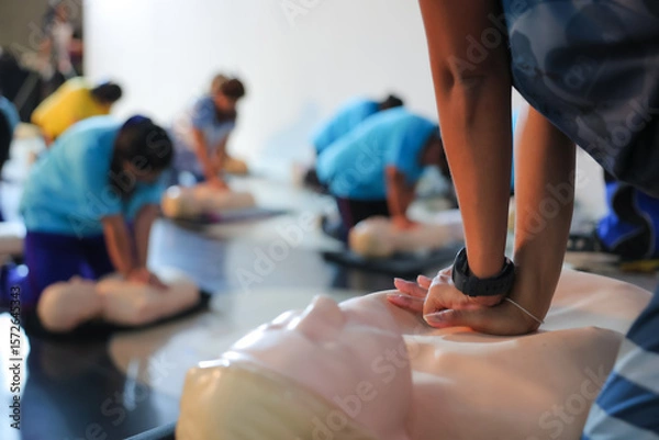 Fototapeta A person performs CPR chest compressions on a during a training session, highlighting essential life-saving techniques and emergency preparedness.	
