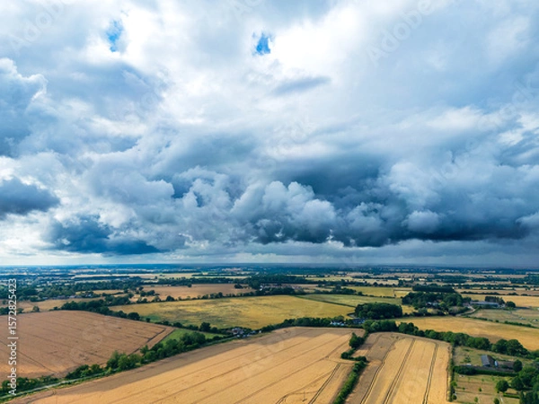 Fototapeta Rolling storm clouds seen gathering over a dry, summer fields in rural Essex, UK. Funnel clouds would shortly form and severe hailstones.