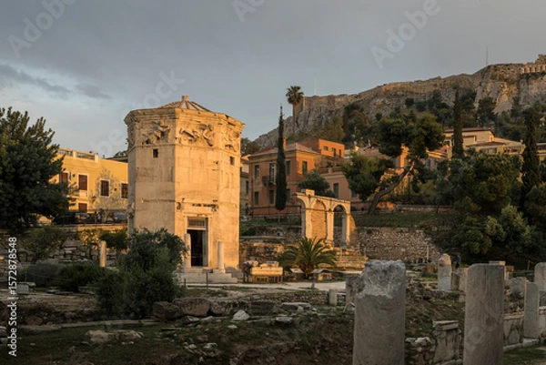 Fototapeta The Horologion of Andronikos Cyrrhestes, an ancient octagonal tower used as a weather station with sundials & a wind vane, in Athens Greece. The setting sun is lighting up the ancient structure