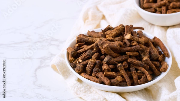 Fototapeta closeup pile of dry dandelion root herb for loose tea in bowl on white table background with copy space