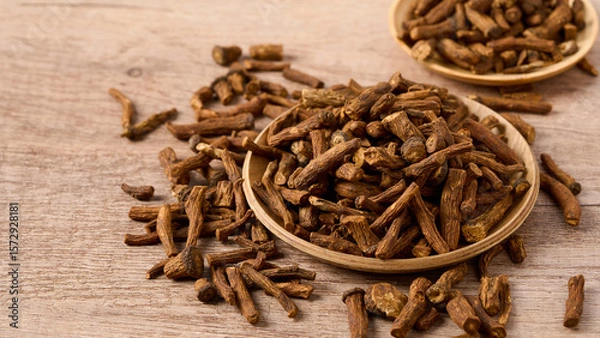 Fototapeta closeup pile of dry dandelion root herb for loose tea in wood bowl on wooden table background with copy space