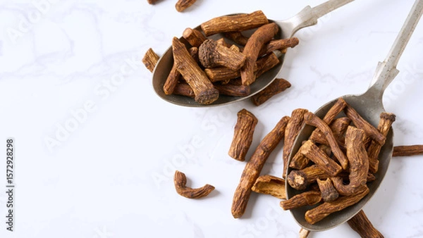 Fototapeta closeup pile of dry dandelion root herb for loose tea in metal spoon on white table background with copy space