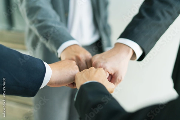 Fototapeta united team raises clenched fists in determination, working together to overcome challenges push forward toward business success and shared goals.
