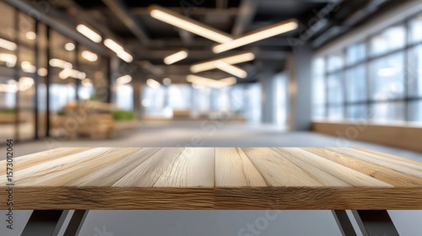 Obraz A clean wooden table surface in a modern office with blurred bright lights and glass walls in the background