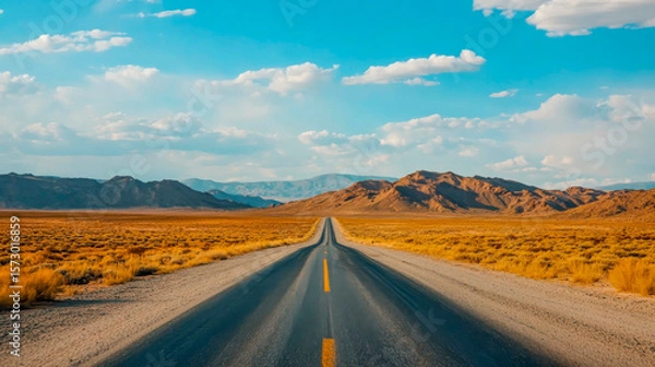 Fototapeta Driving on a winding desert road, a vast expanse of dry terrain stretches into the horizon. The sun lights up the golden sands, inviting exploration and adventure. Nature unfolds in solitude