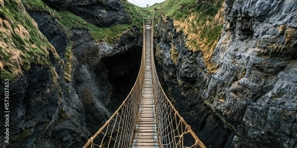 Obraz A narrow rope bridge hanging between two cliffs
