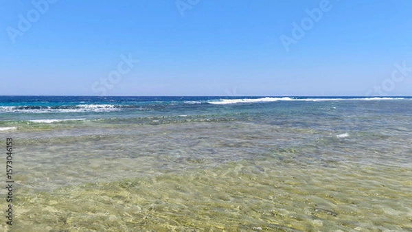 Fototapeta Natural background with sea view with underwater coral reef of Red Sea in Egypt. Clear day, clean blue sky, sunny day. Ideal for summer tourism and recreation.