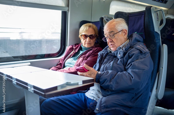 Obraz Senior Couple Using Smartphone While Traveling by Train