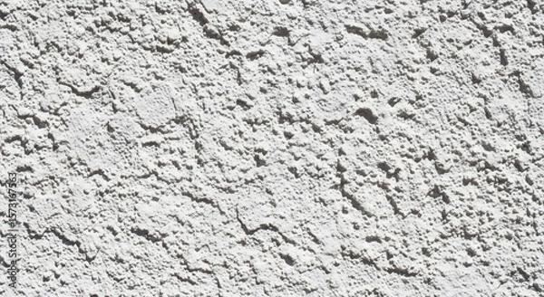 Fototapeta Textured White Stucco Wall: Close-Up of Rough Exterior Surface in Bright Sunlight